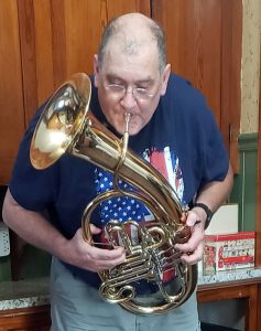 Tren Cheshier playing Wagner tuba at home during lockdown